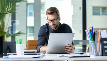 a man holding a clipboard sitting on his desk