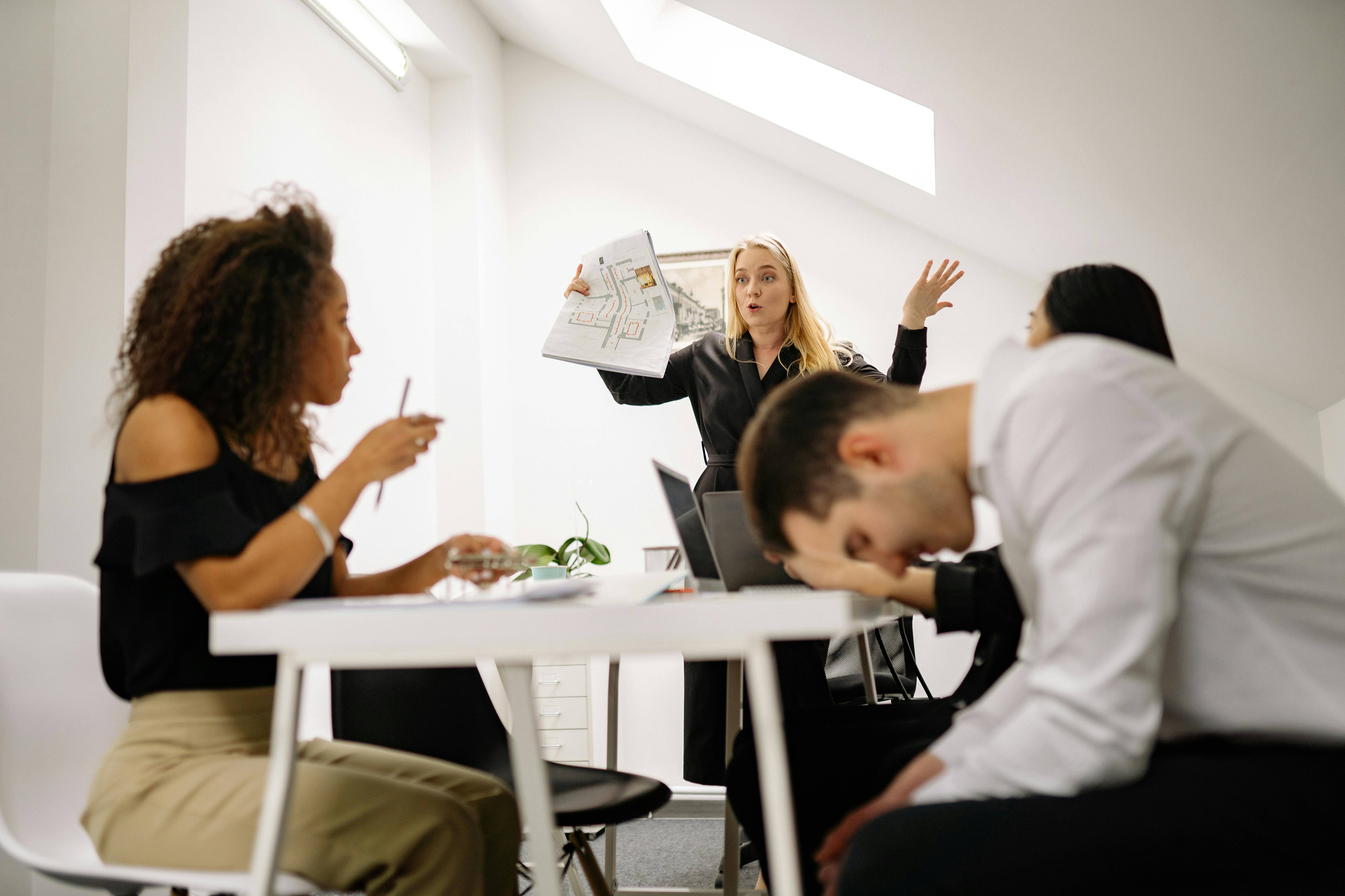 group of people discussing with a woman leading and guy seemingly stressed or tired